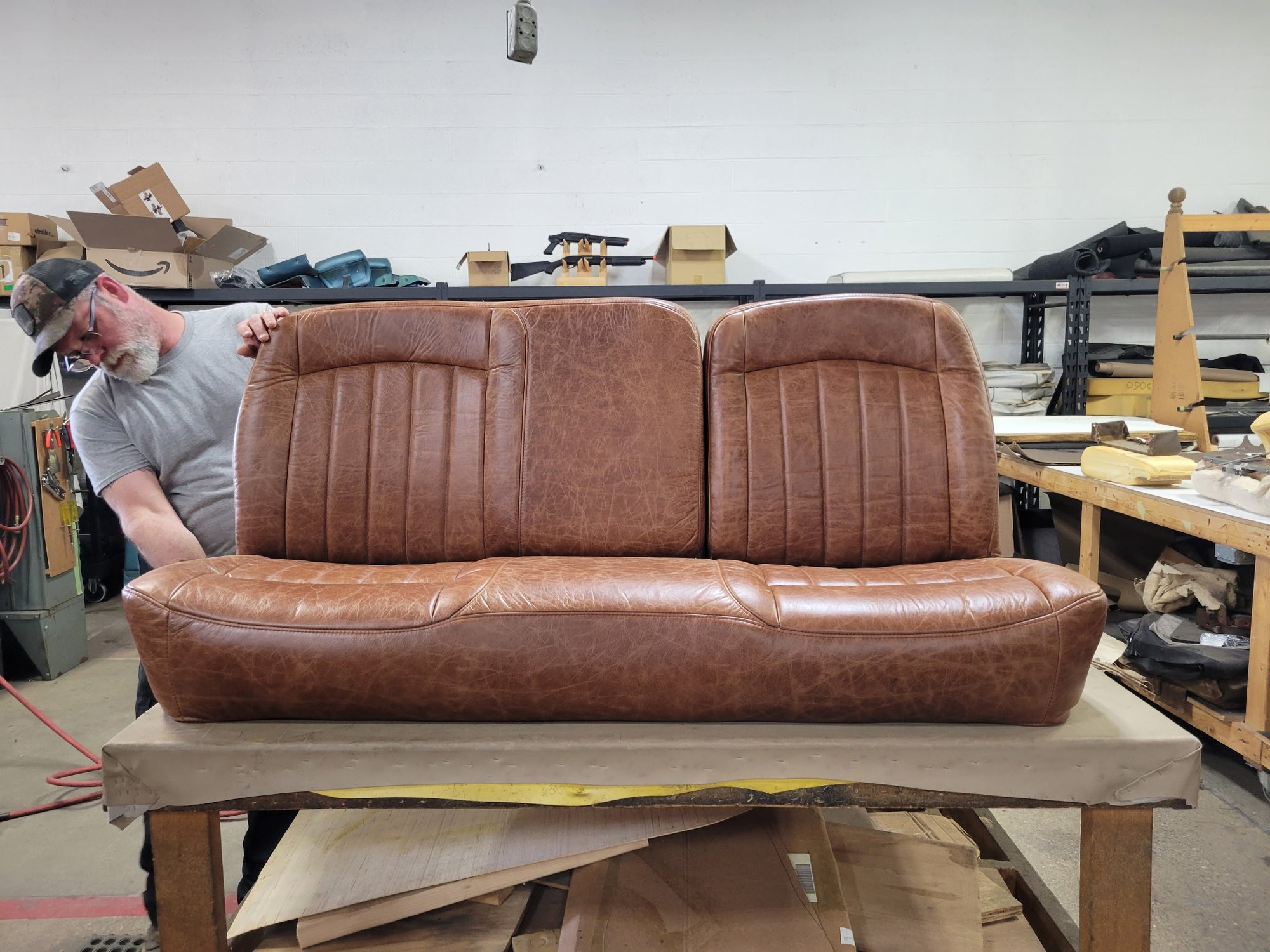 A hand-crafted brown bench seat being finished in the upholstery shop