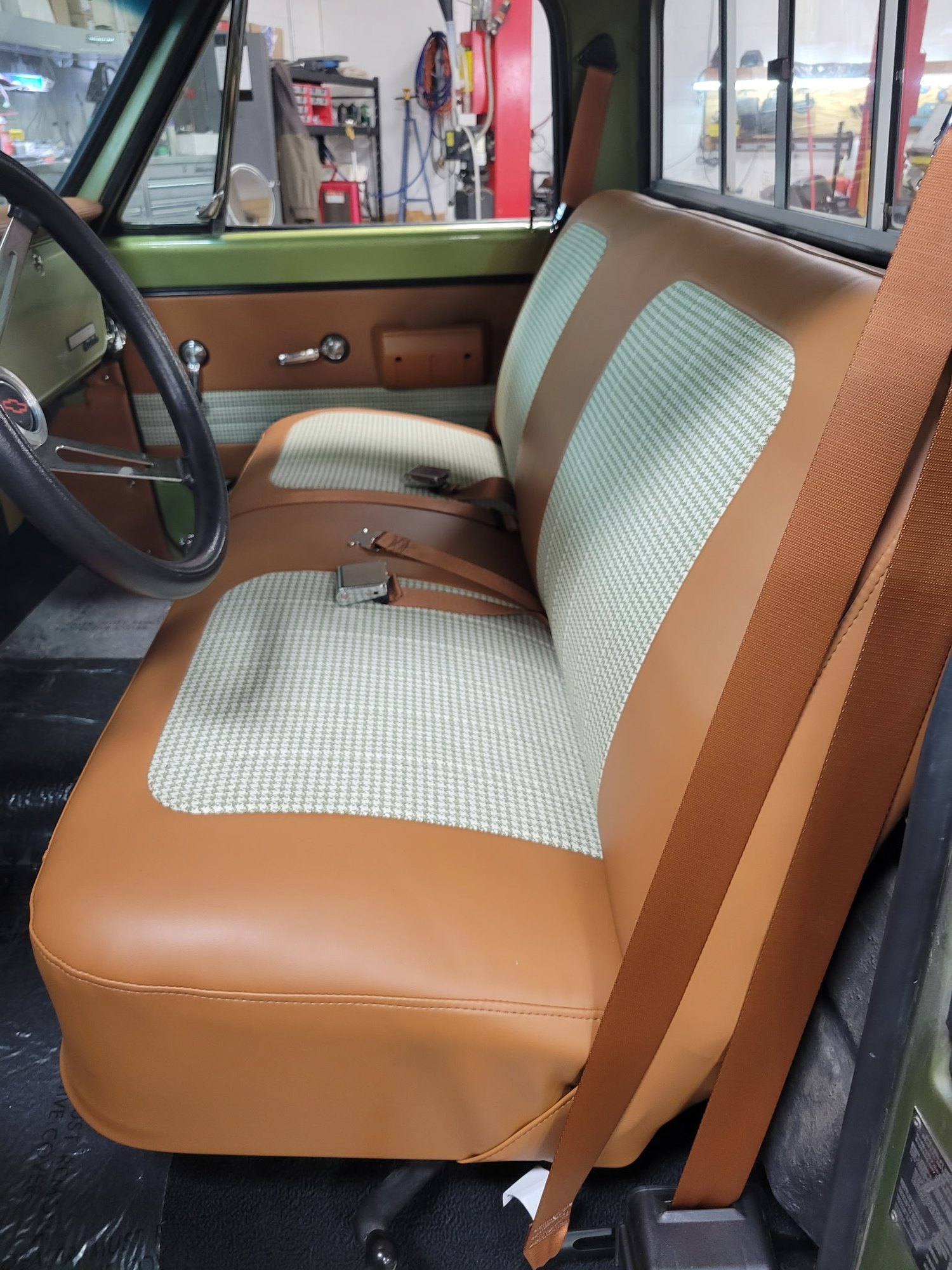 Finished tan and houndstooth bench seat in a classic Chevrolet truck