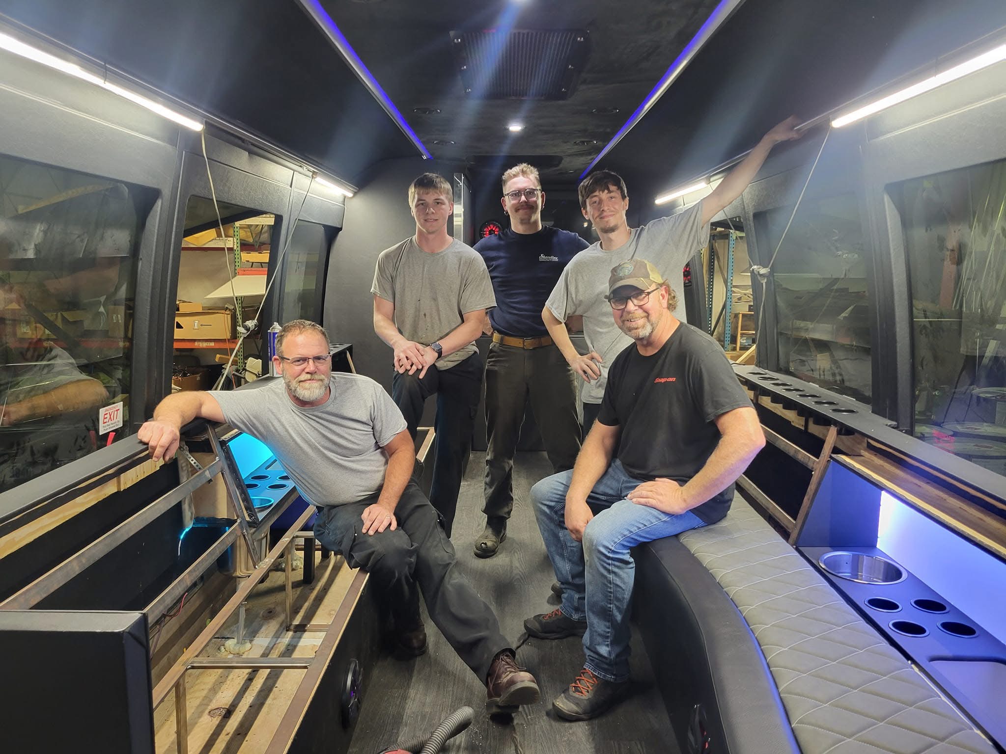 Craftsmen standing inside the custom coach interior during the build