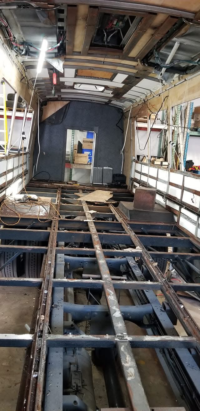 Specialty coach interior stripped to its structural frame before rebuilding