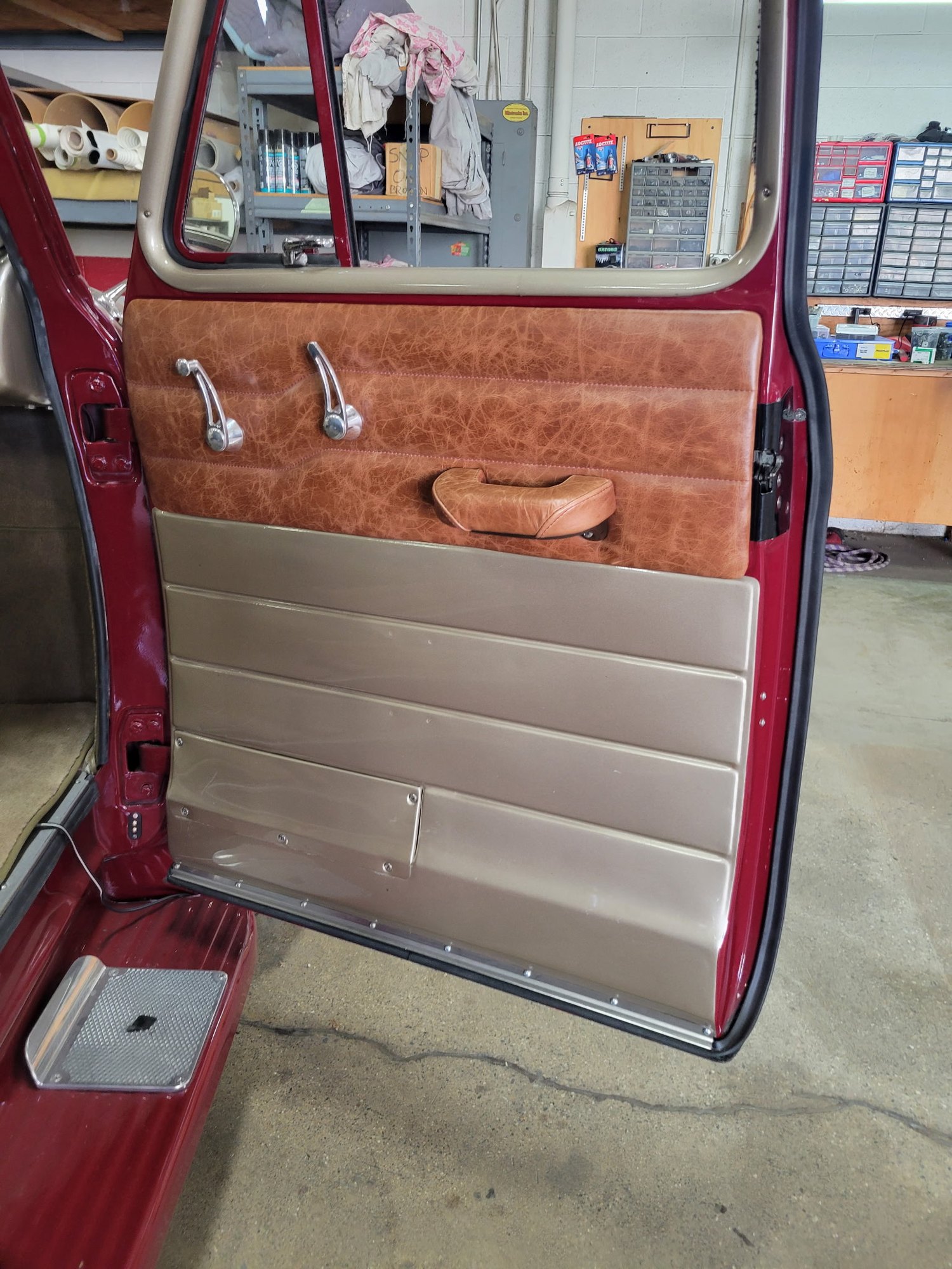 Hand-built brown leather and metal door panel in a classic vehicle