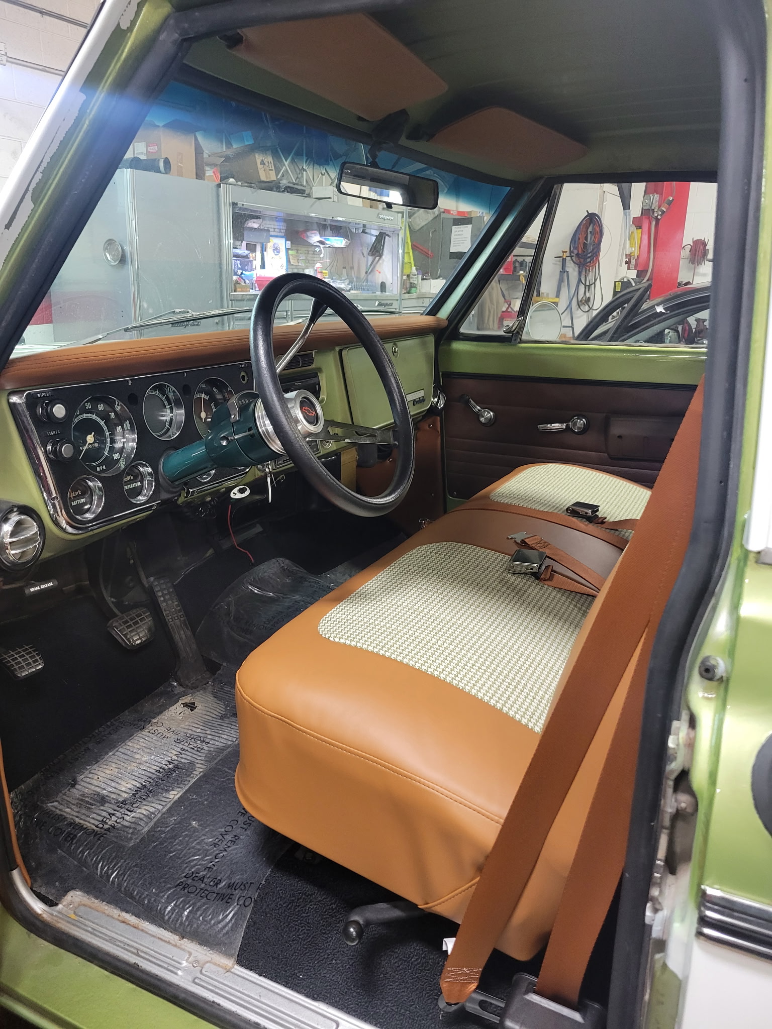 Tan and houndstooth custom interior inside a green classic Chevrolet truck