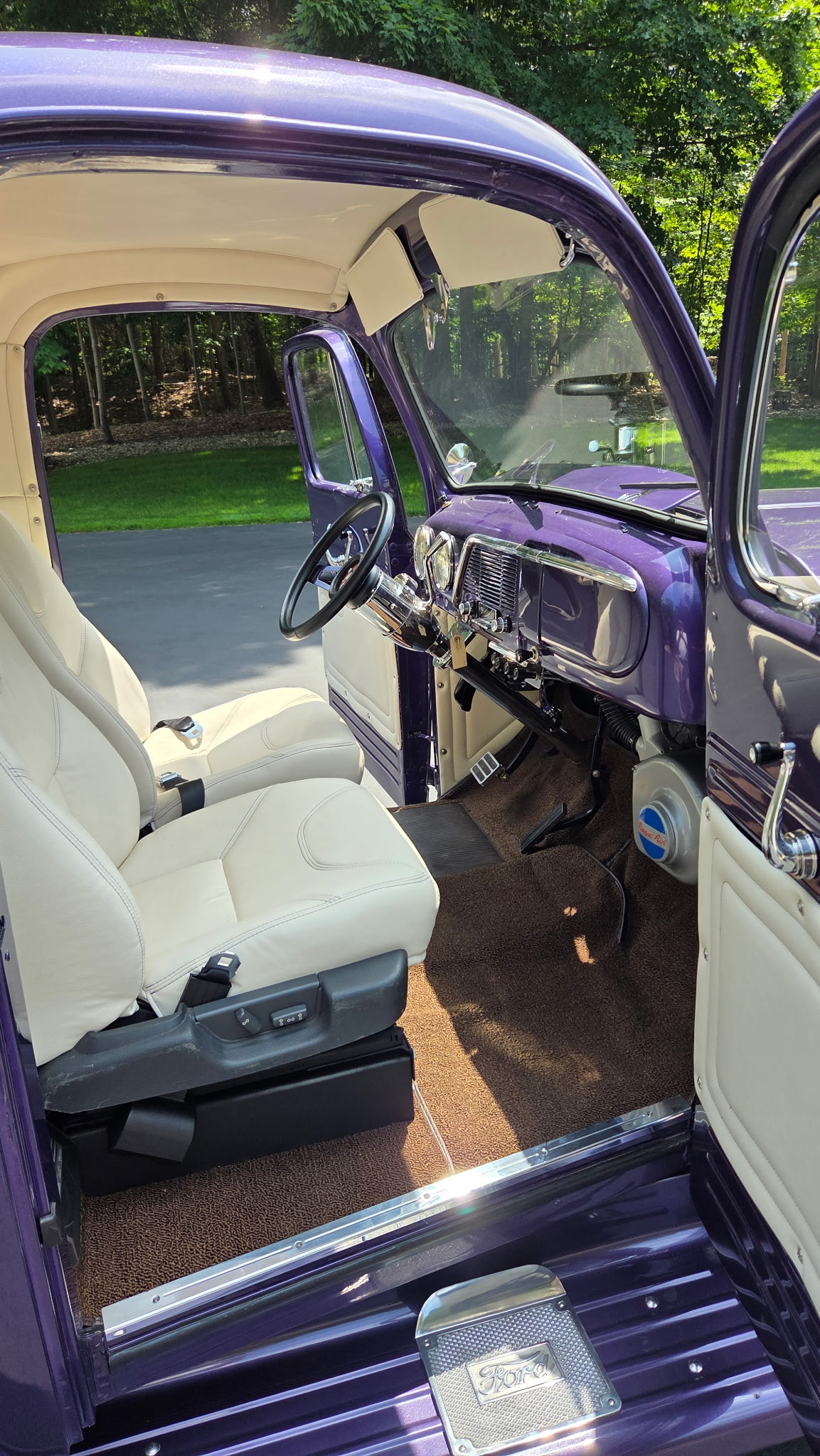 White custom bucket seats and finished interior in a purple classic Ford truck