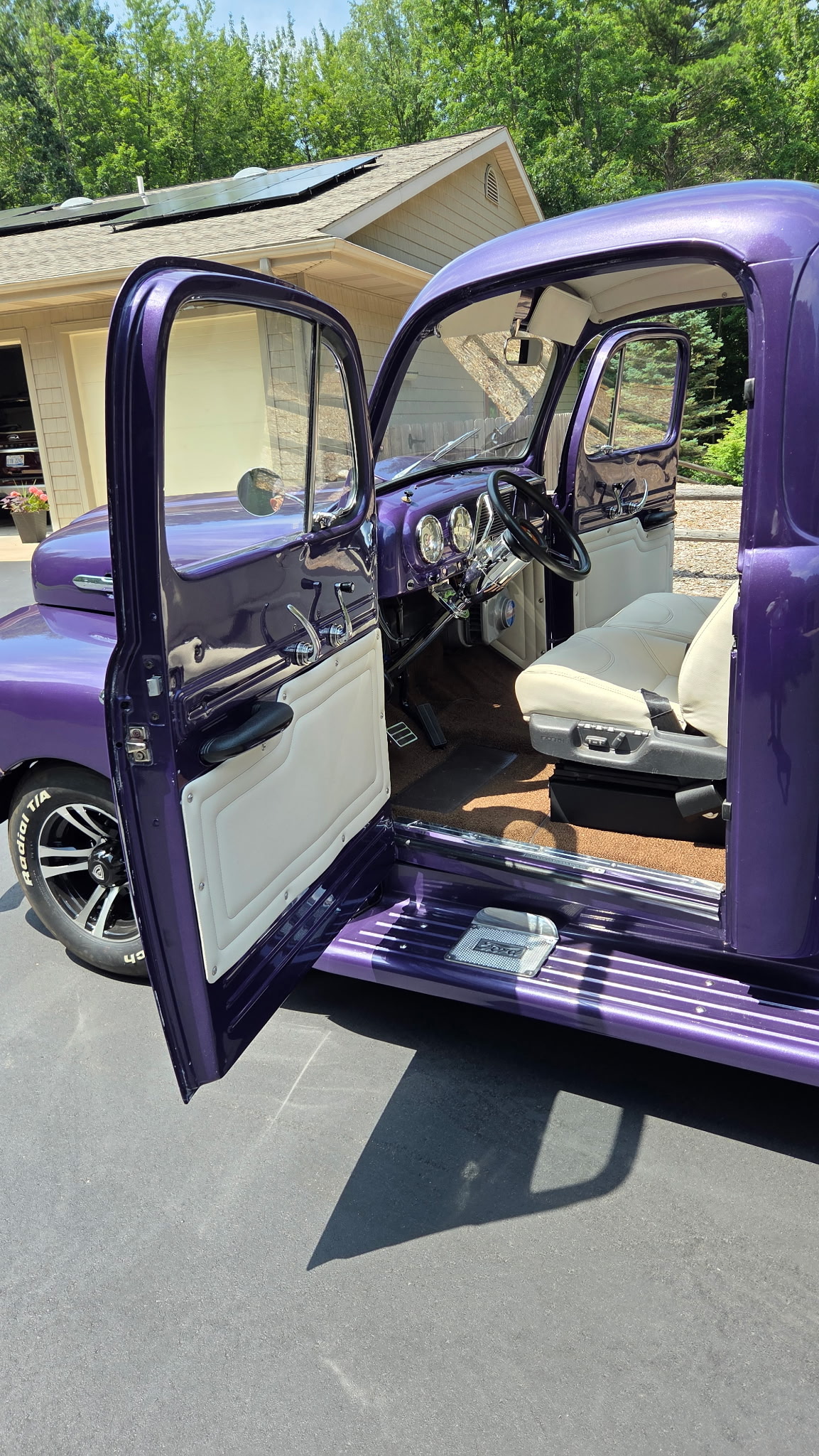 Purple classic Ford truck with white custom seats, door panels, and headliner